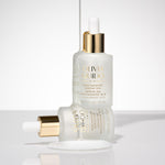 Olivia Quido Skincare Niacinamide bottle sitting on another bottle in environment as part of the Skin Refining set